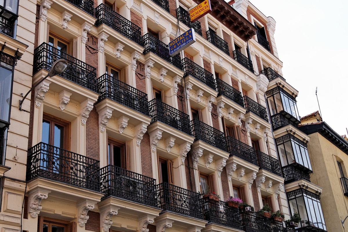 Fachada de un edificio de viviendas con balcones de forja en la calle Magdalena de Madrid